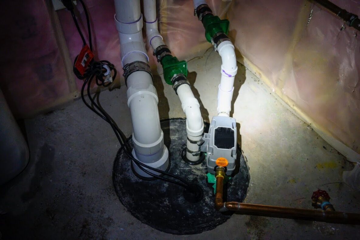 sump pump in the dark lit up by a flashlight beam